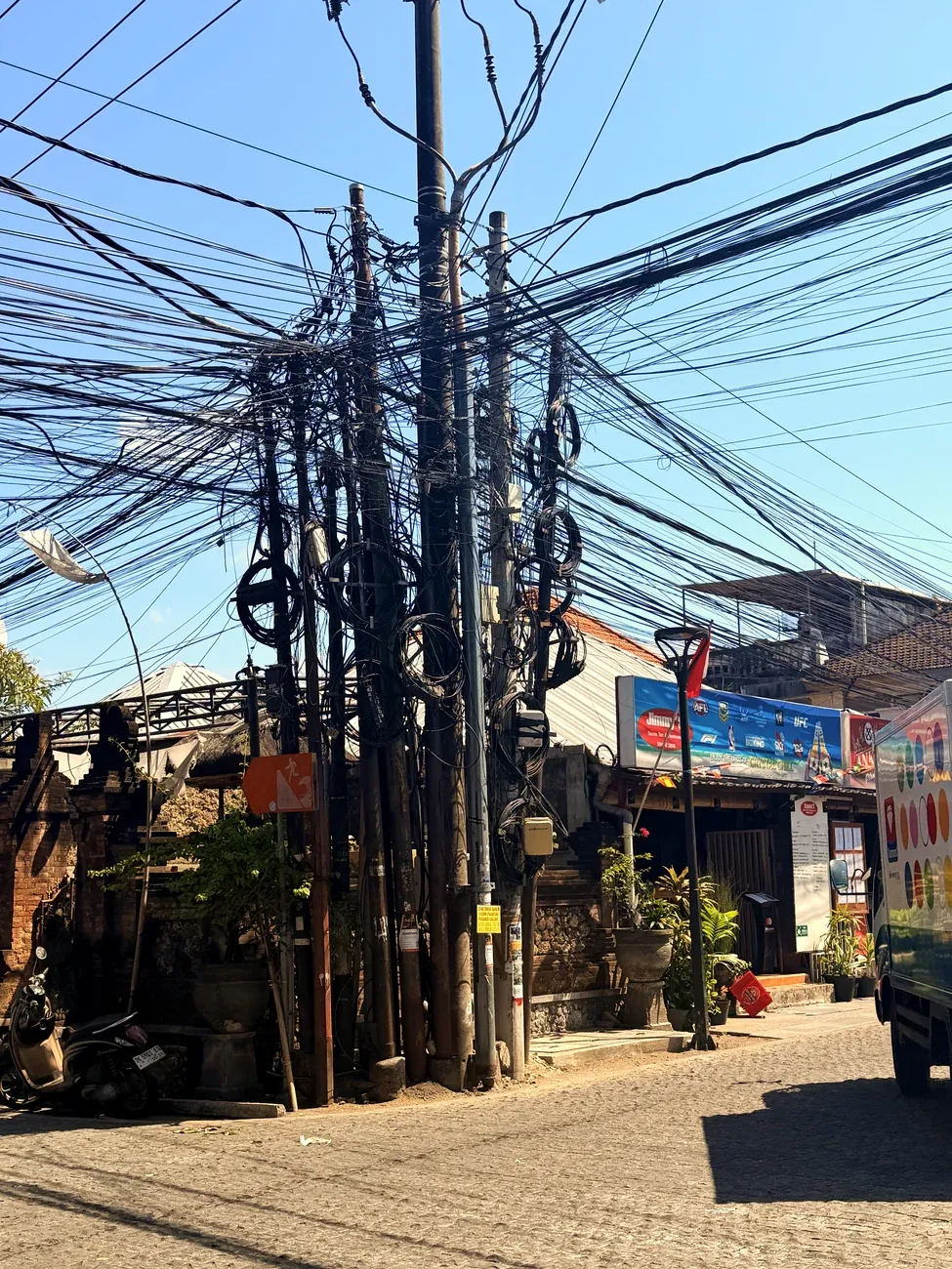 Bündel von Stromkabeln über einer Strasse in Kuta