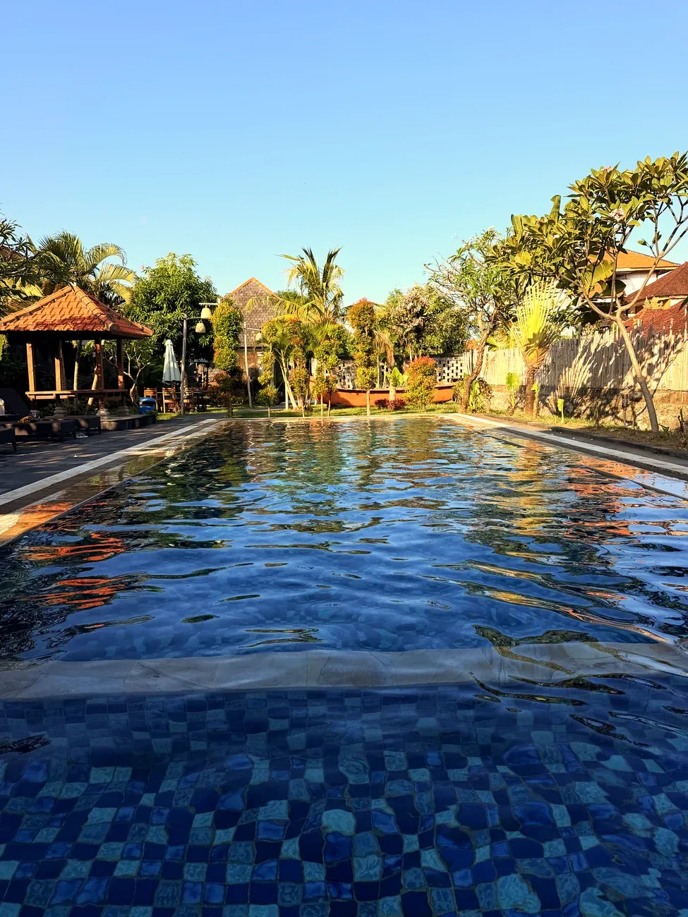 Der Pool des Le Lima Hotels in Kuta mit Liegen und Palmen