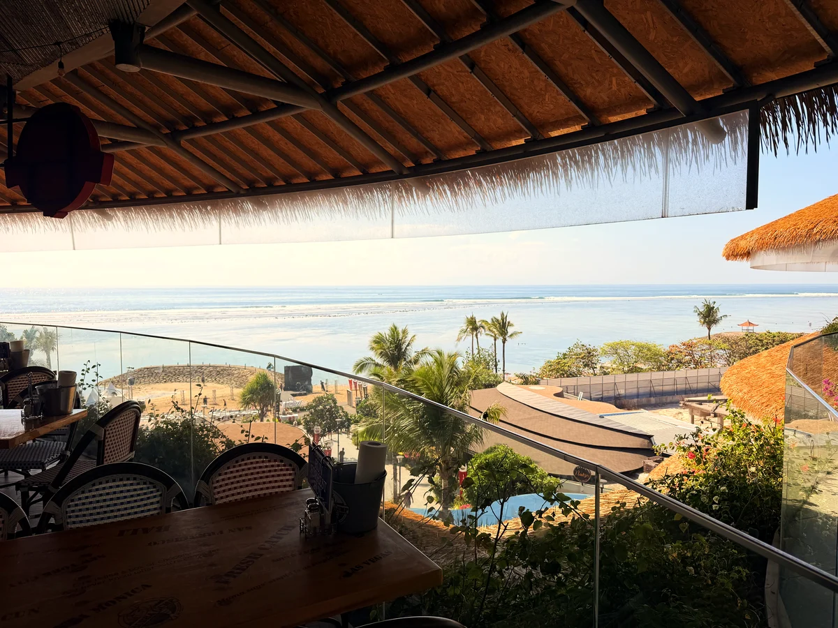 Blick von einer Terrasse in Sanur über Palmen aufs Meer