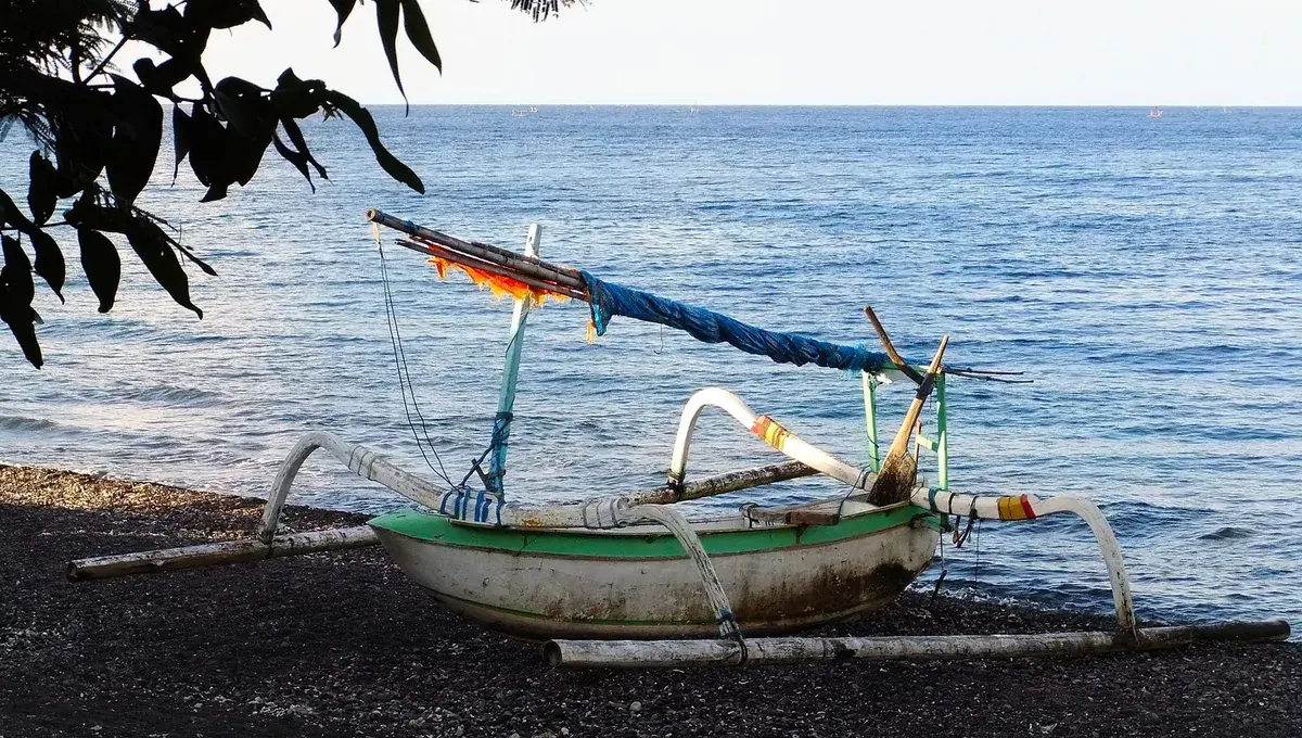 Traditionelles Jukung-Fischerboot auf dem Kieselstrand von Amed