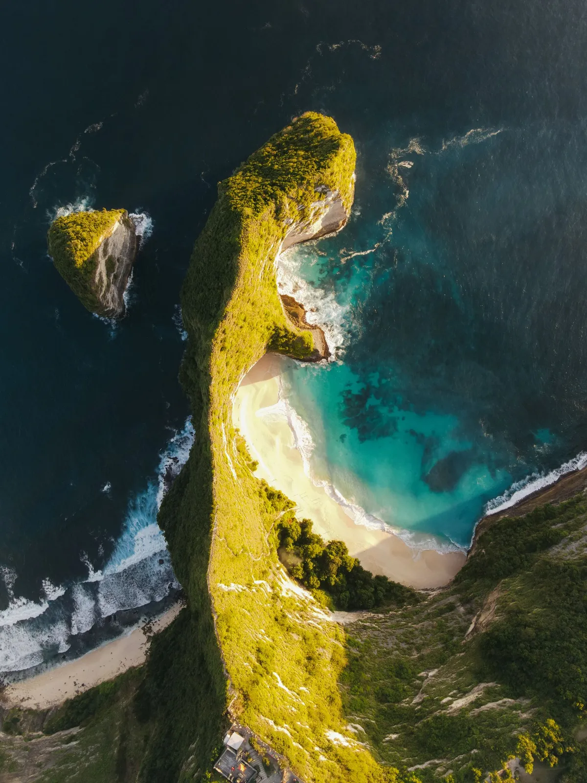 Kelingking Beach von oben: Klippenruecken, weisser Strand und tuerkises Wasser