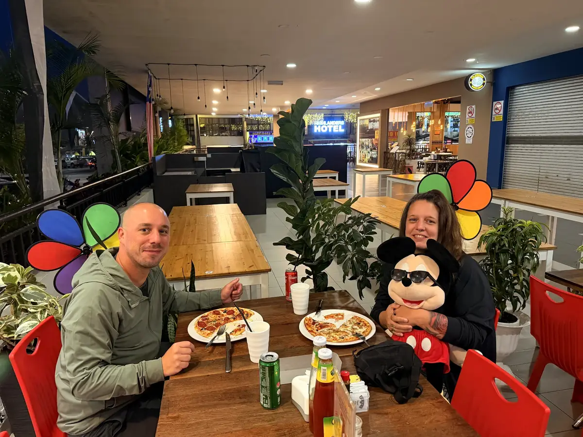 Fabienne und Marc beim Pizzaessen, Fabienne mit einer Micky-Maus im Arm