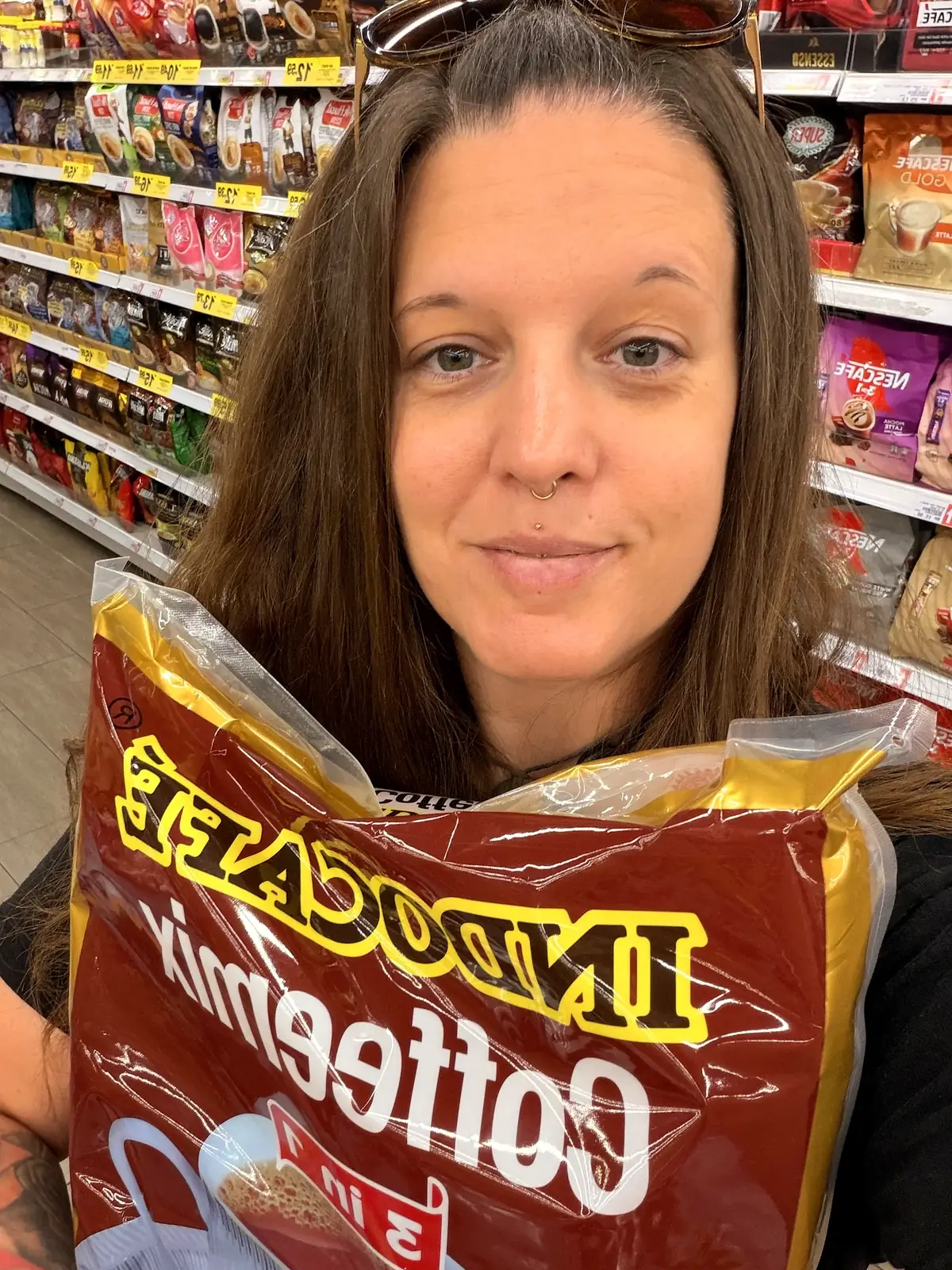 Fabienne mit einer grossen Packung Kaffee im Supermarkt