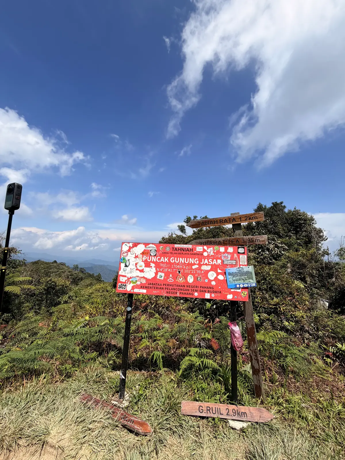 Das rote Gipfelschild Puncak Gunung Jasar unter blauem Himmel