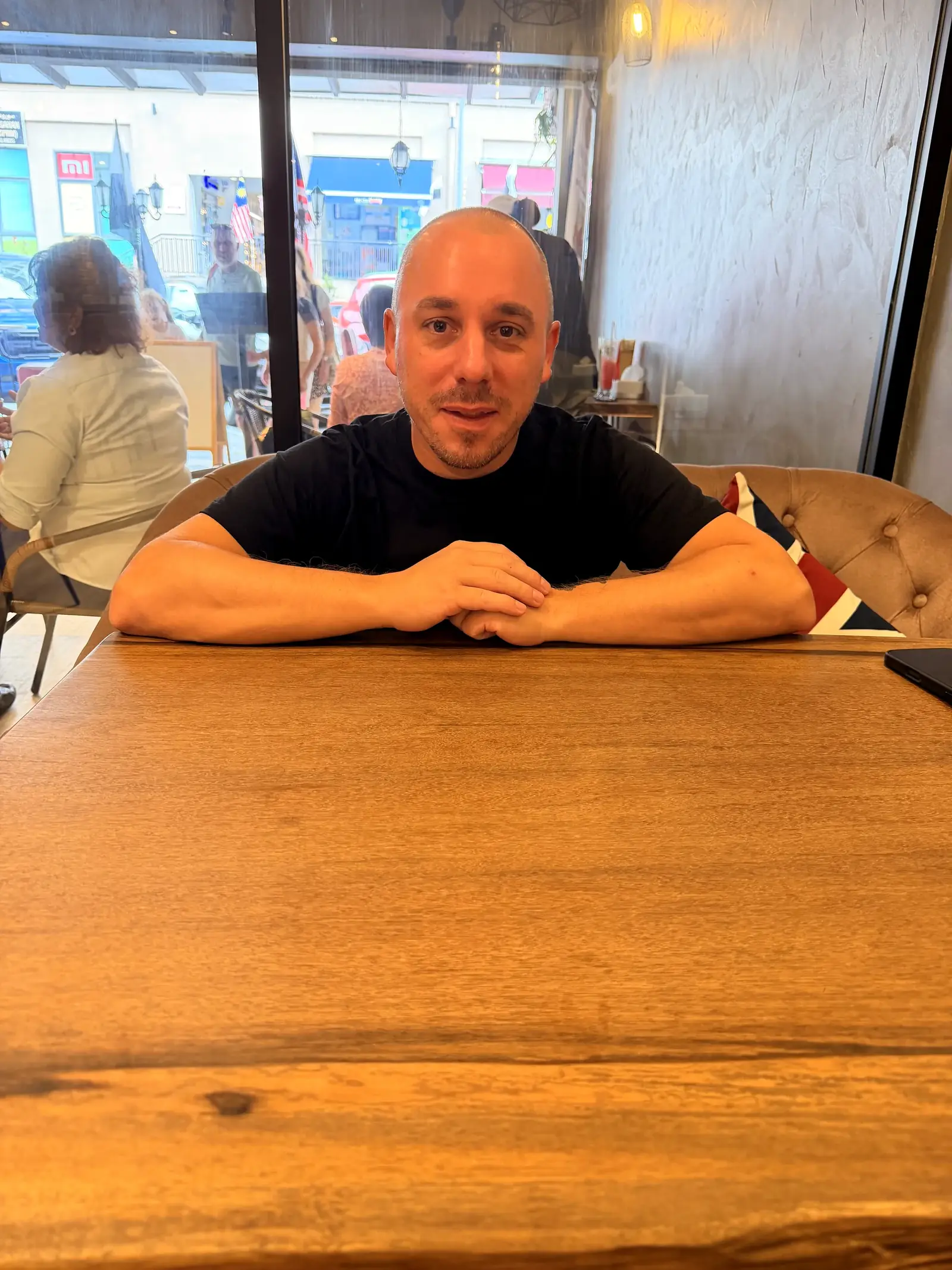 Marc sitzt an einem Tisch in einem Café