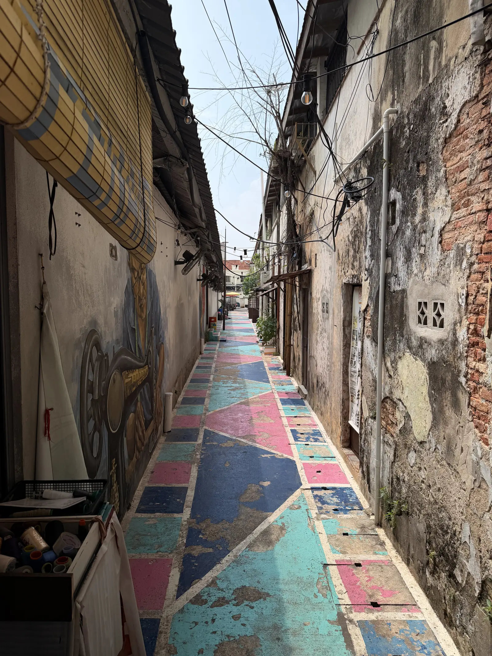 Schmale Gasse mit bunt bemaltem Boden und alten Hauswänden