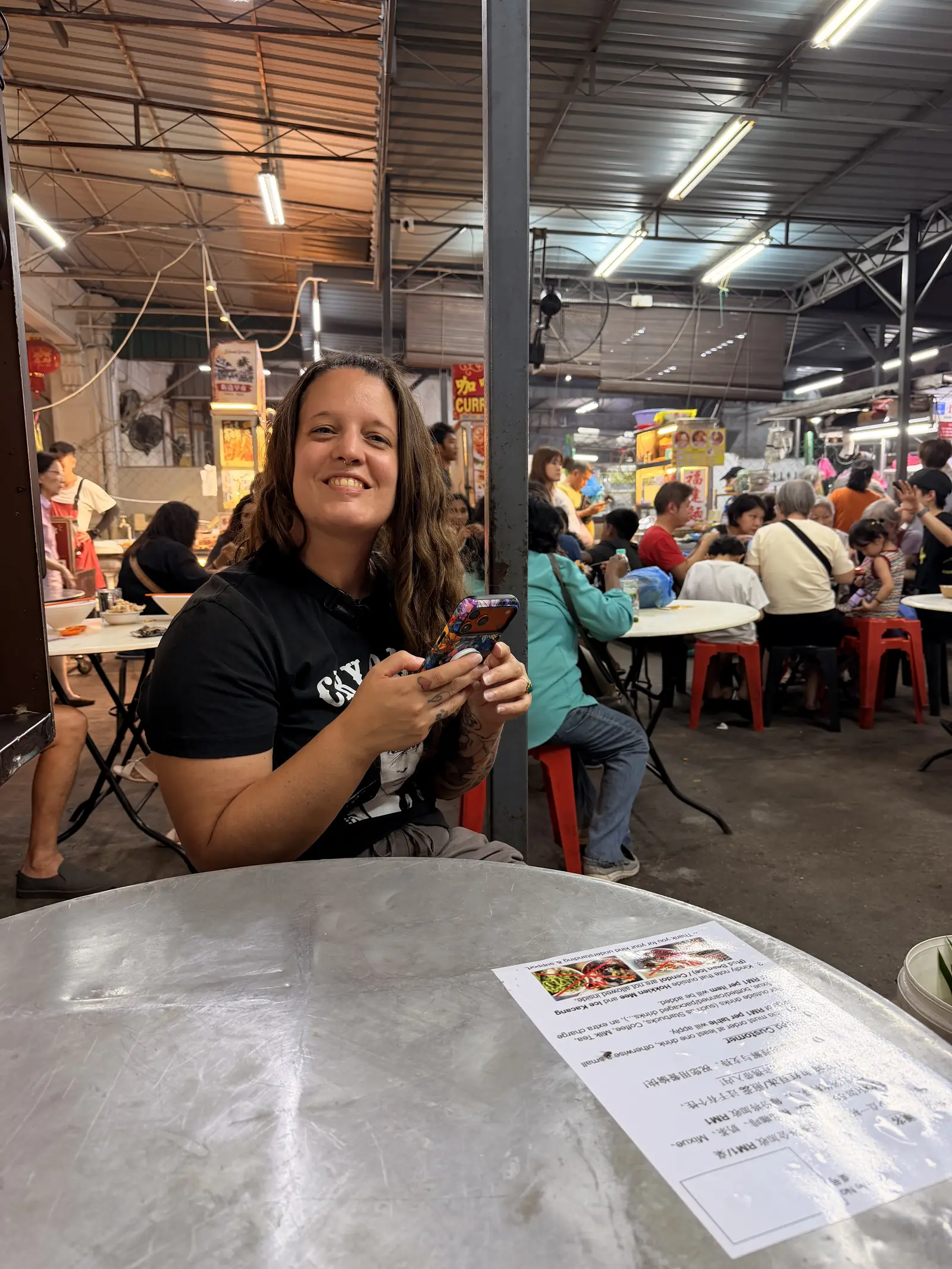 Fabienne an einem Tisch in einer Garküchenhalle