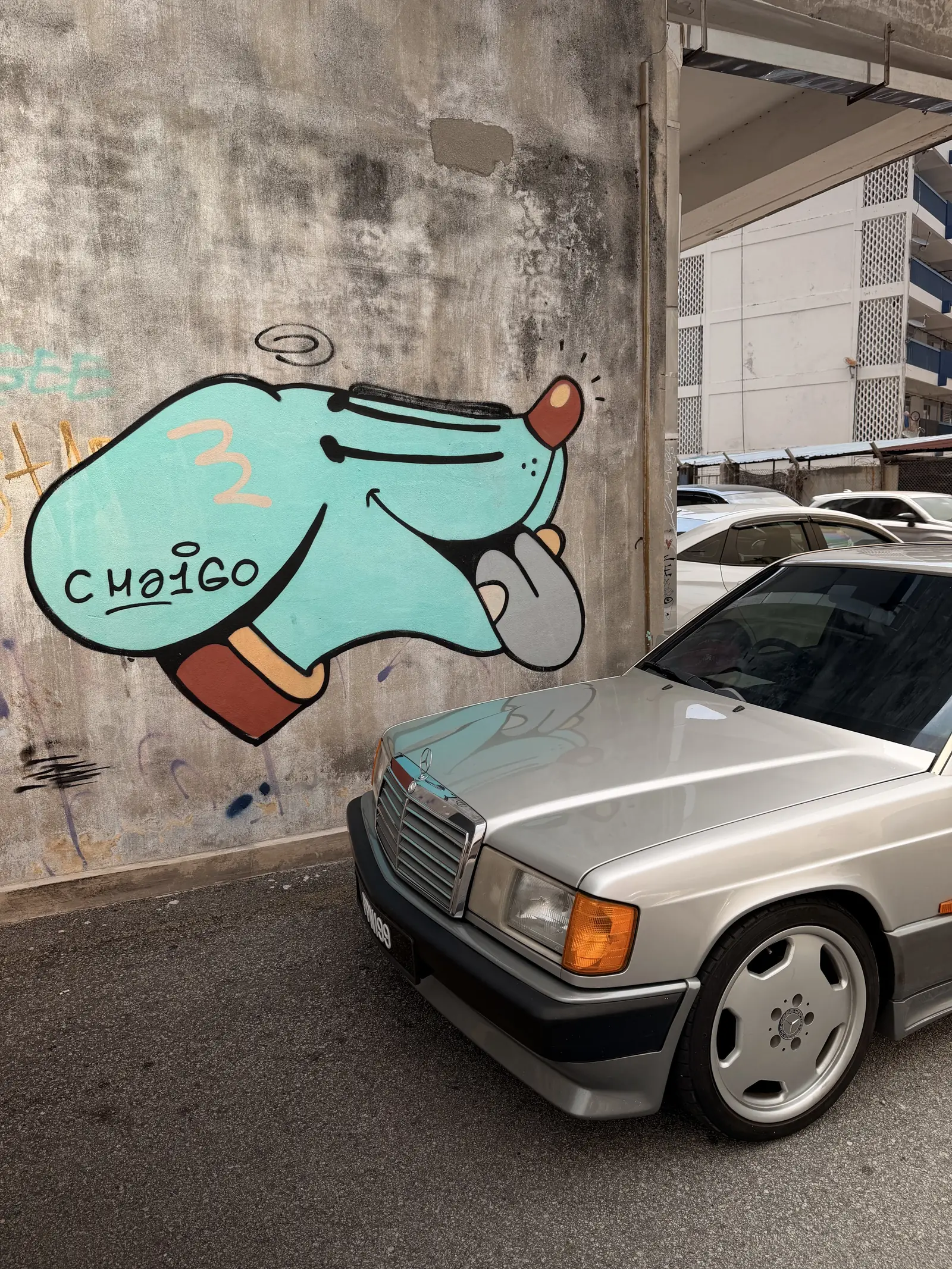 Wandbild über einem alten Mercedes an einer Hauswand