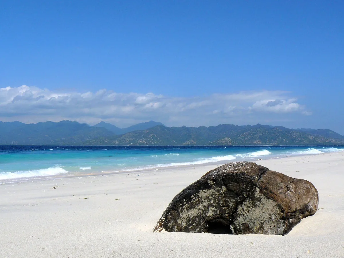 Weisser Strand mit Felsblock auf Gili Meno