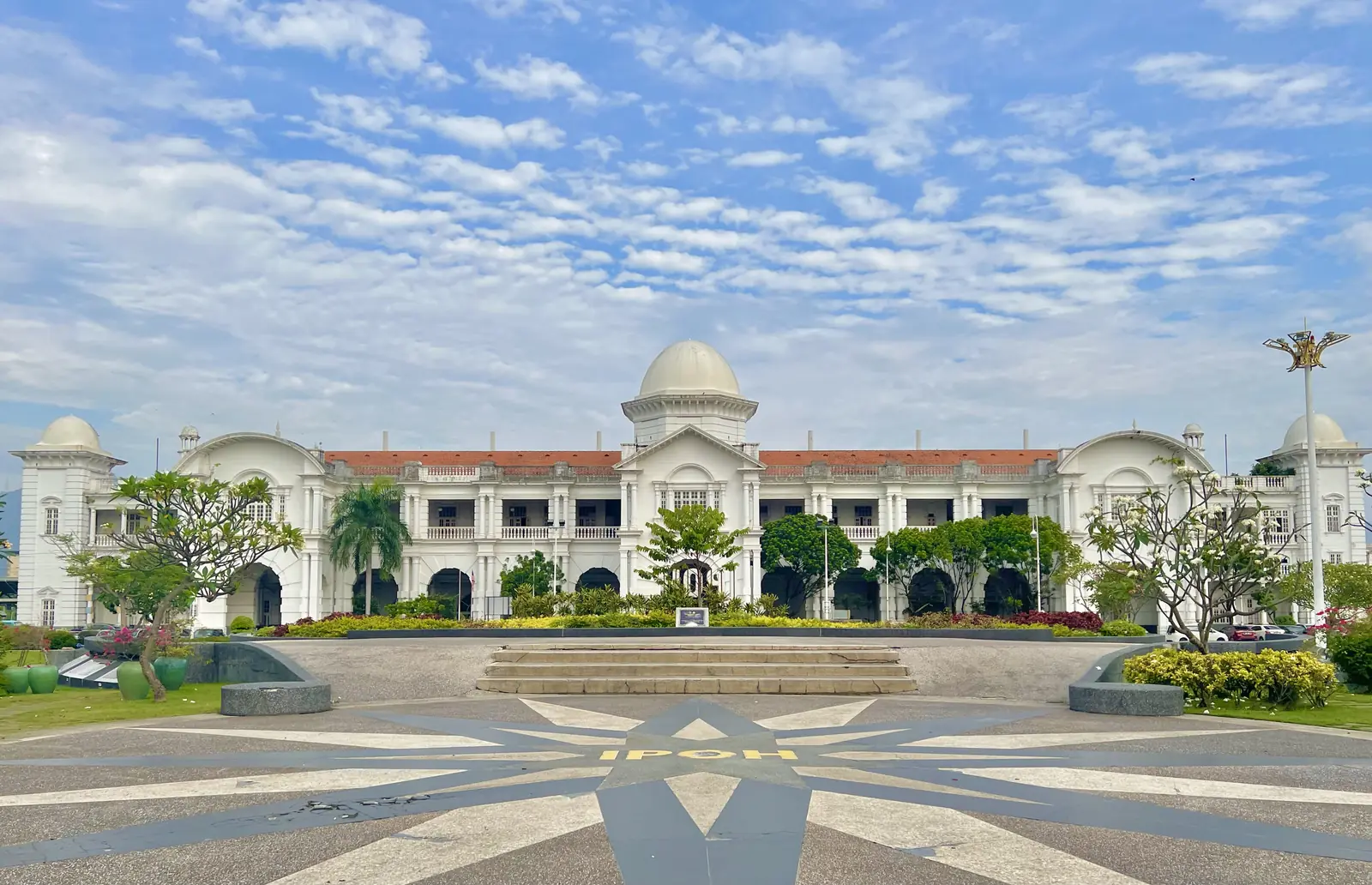 Der weisse Bahnhof von Ipoh mit Kuppeln unter blauem Himmel
