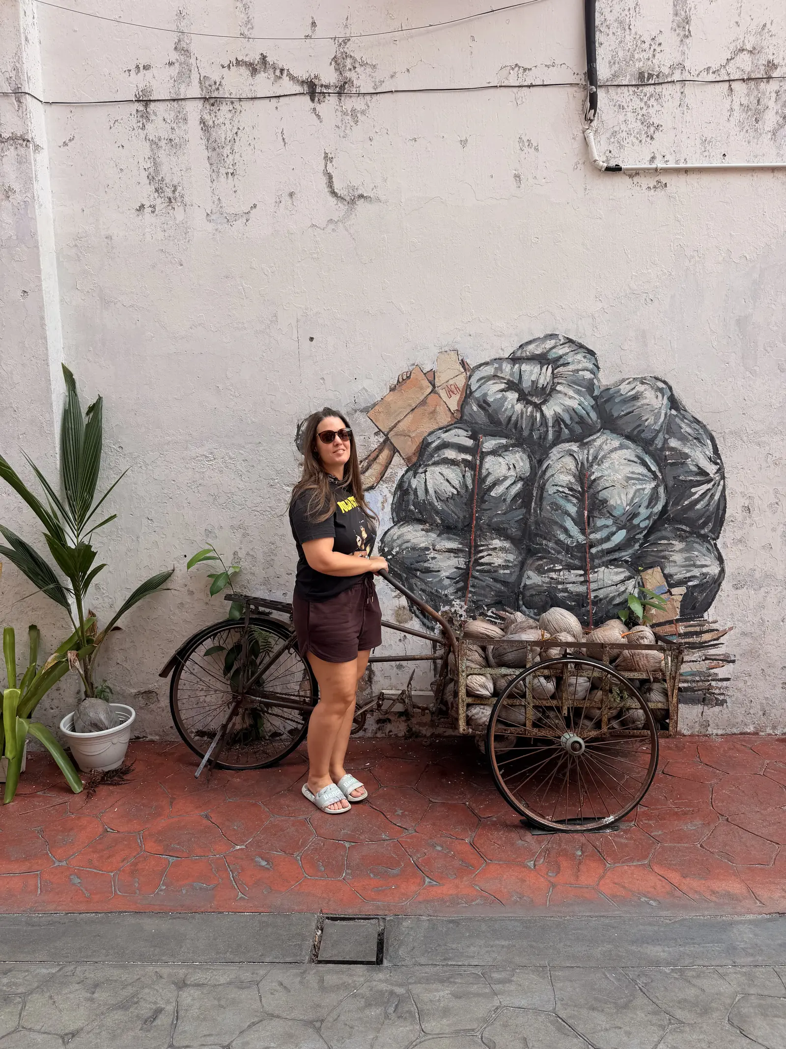Fabienne neben einem alten Velo vor einem Wandbild in der Market Lane