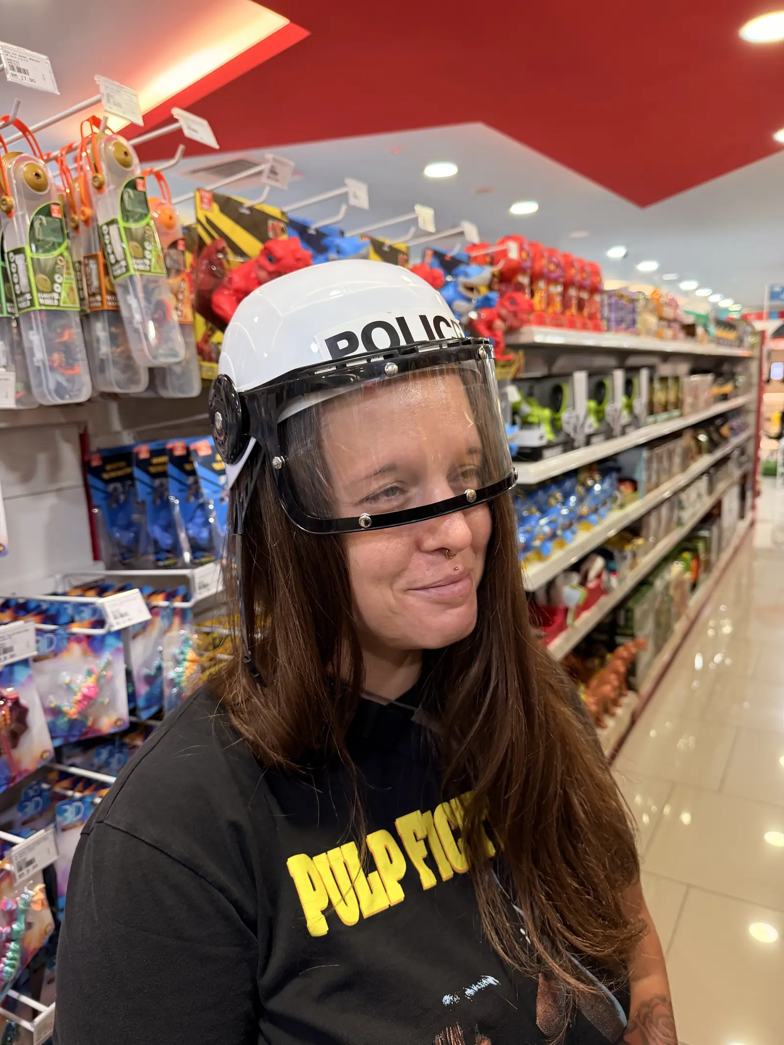 Fabienne mit einem Spielzeug-Polizeihelm in einem Spielwarenladen
