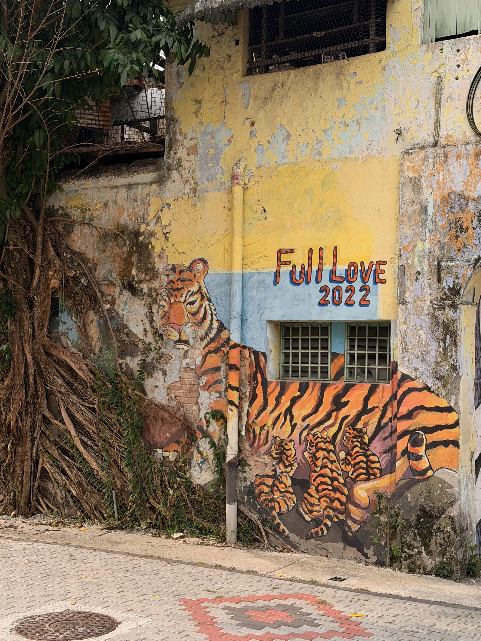 Ein grosser gemalter Tiger an einer gelben Hauswand in der Mural Arts Lane
