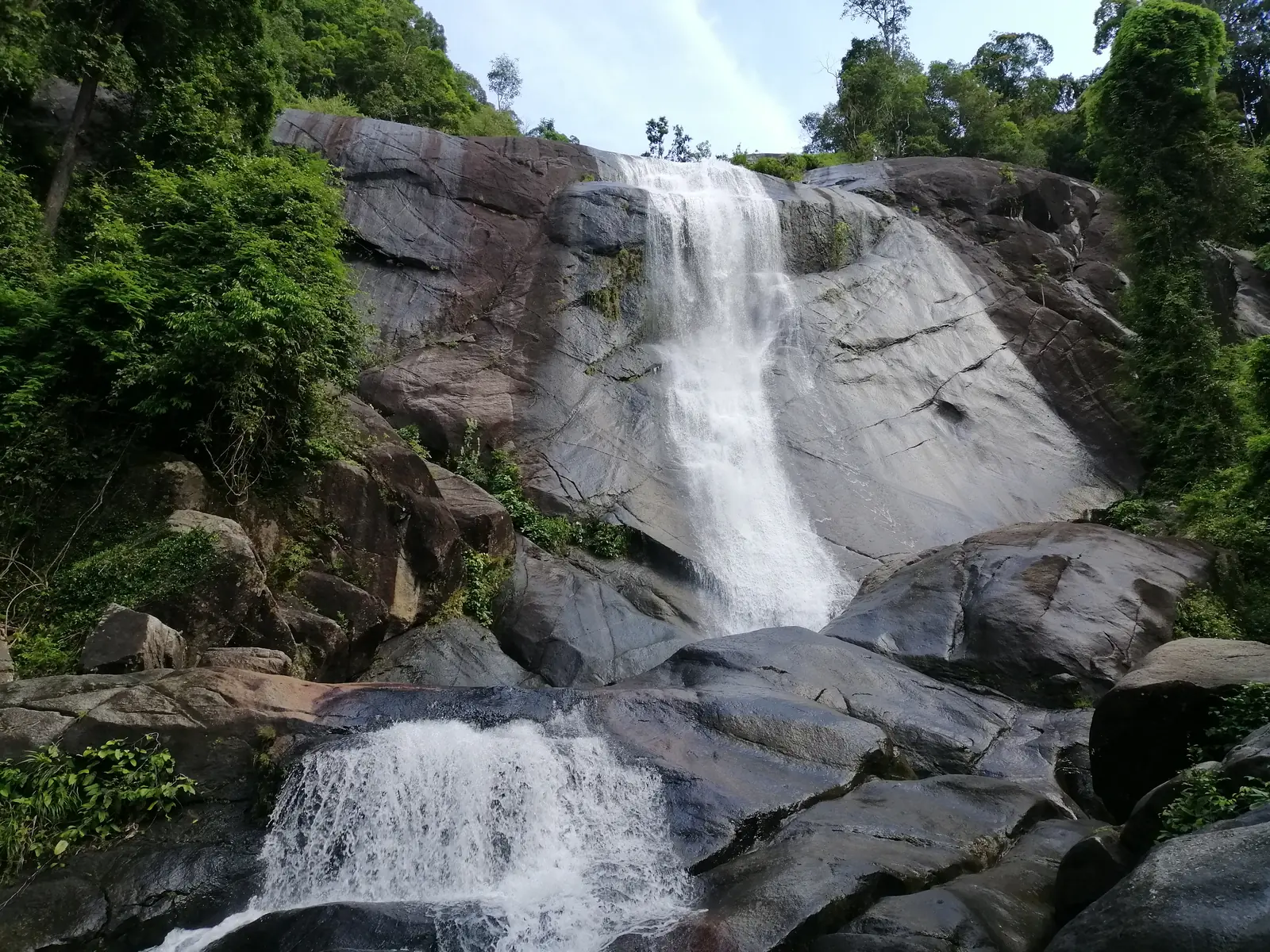 Wasserfall über graue Felsen im Regenwald