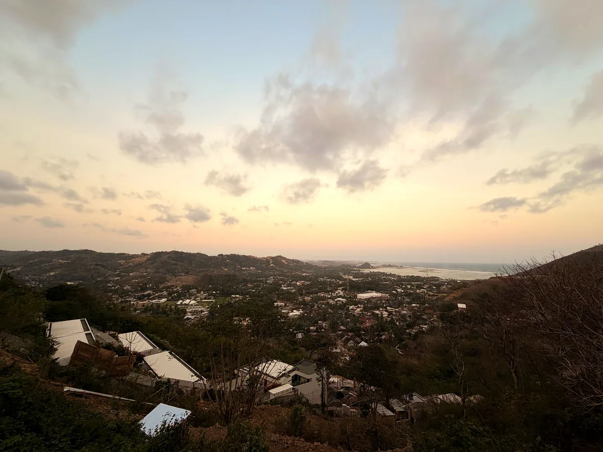 Blick von einem Hügel über Kuta und die Bucht in der Abenddämmerung