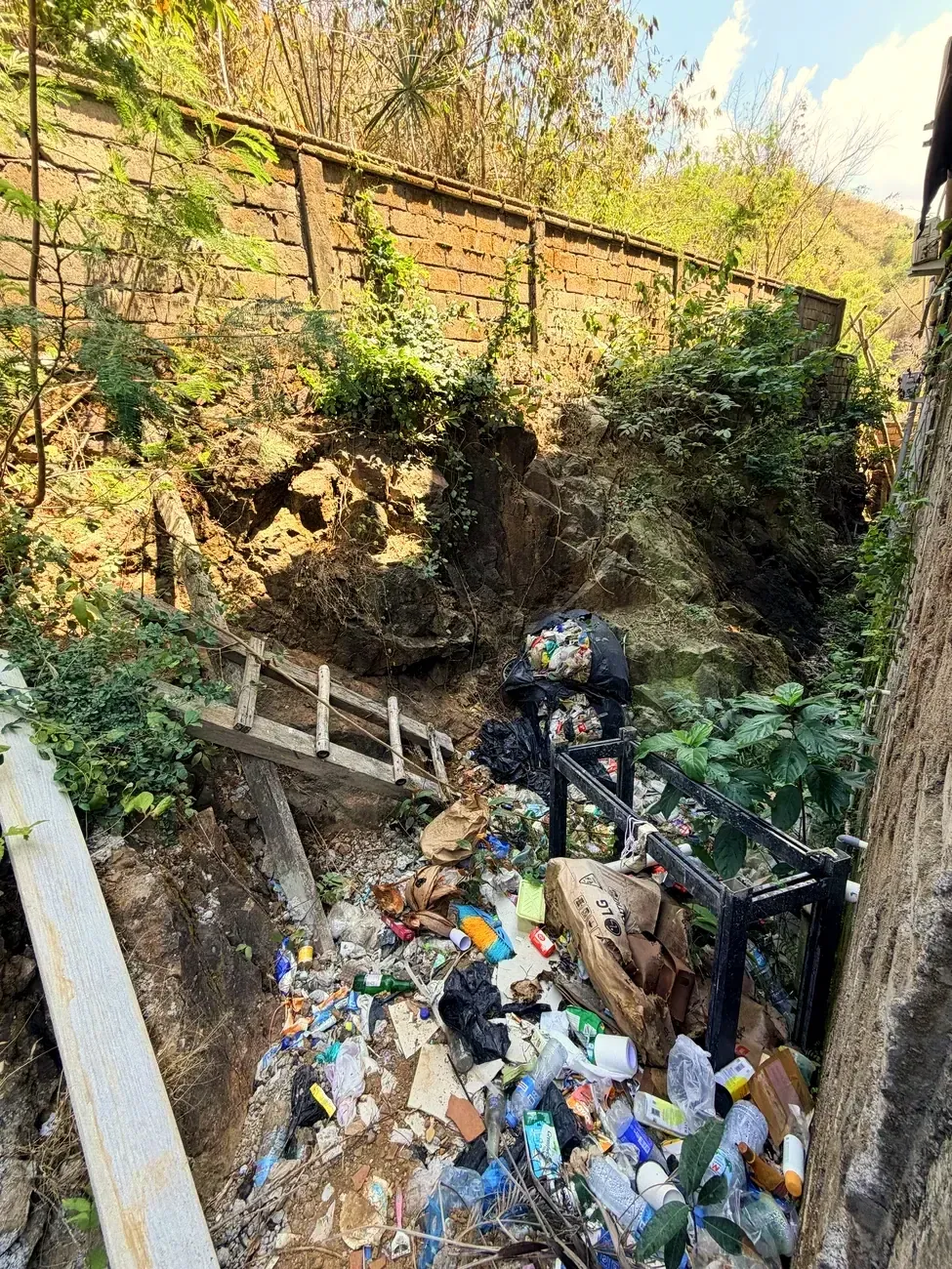 Müll in einer Schlucht neben einem Weg in Kuta
