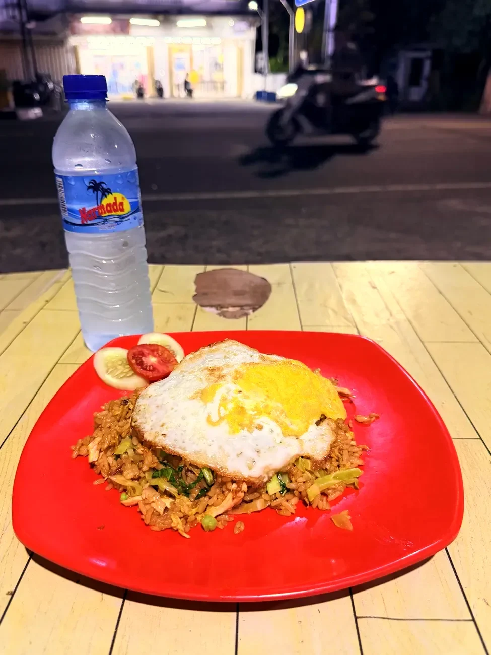 Nasi Goreng mit Spiegelei auf rotem Teller