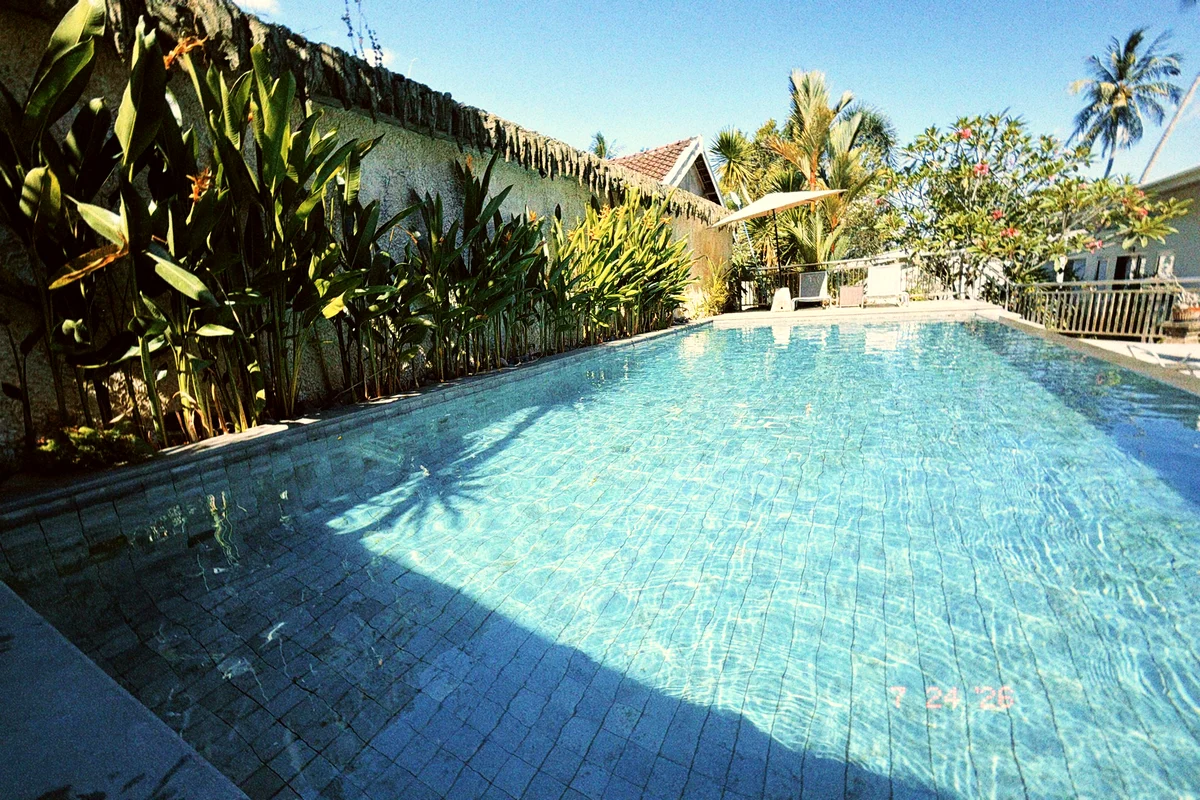 Pool zwischen Palmen und Bungalows