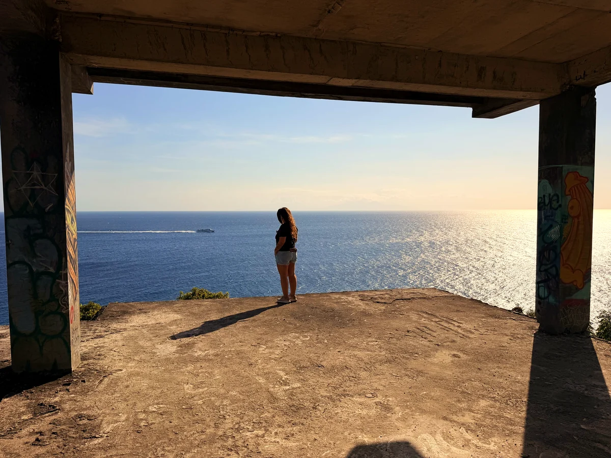 Fabienne steht in der Halle der Ruine und schaut aufs Meer