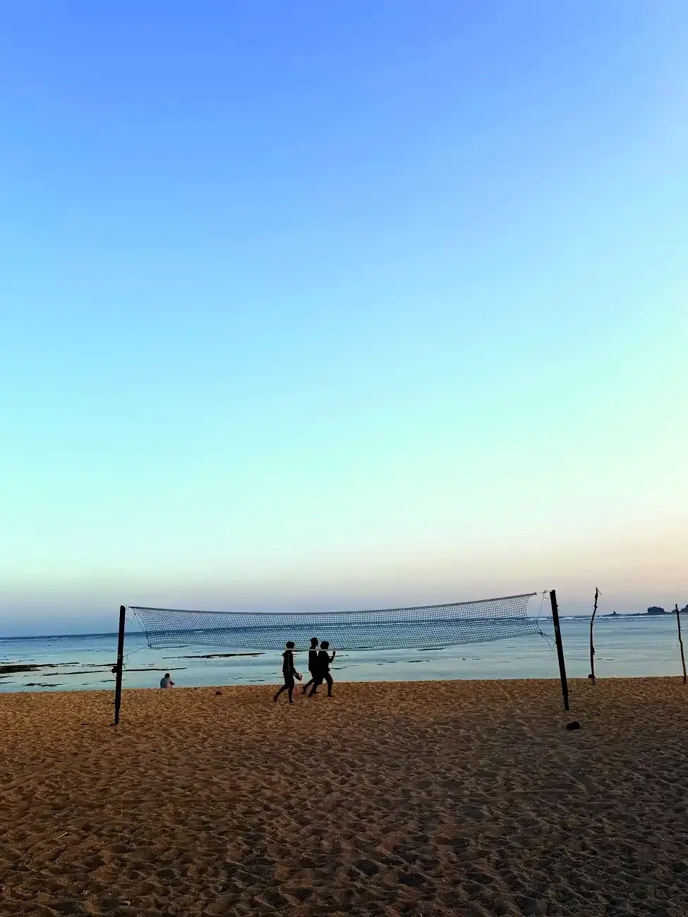 Strand mit Volleyballnetz am Abend