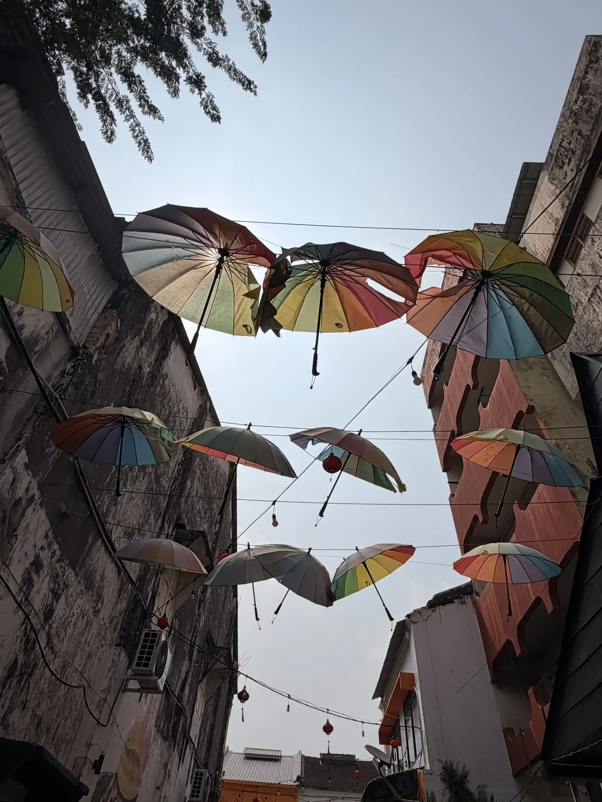 Bunte Regenschirme hängen über einer Gasse in Ipoh
