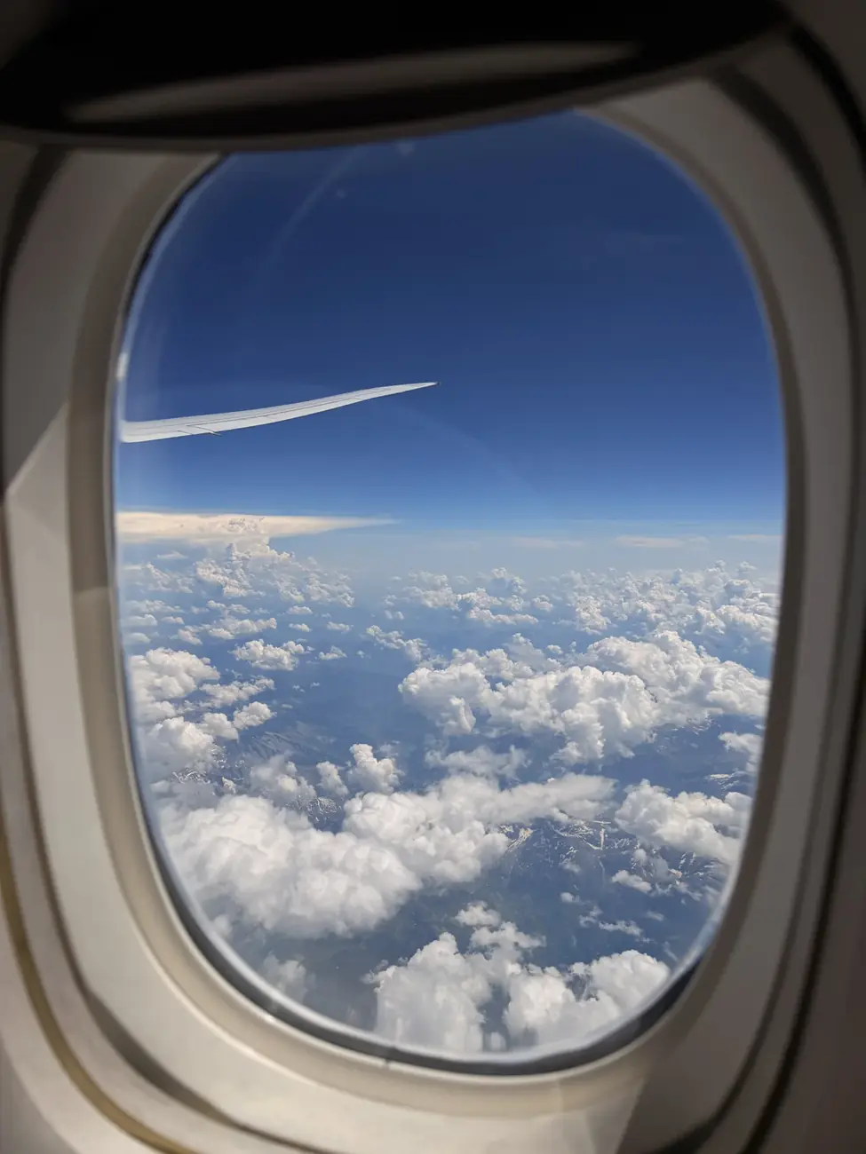 Blick aus dem Flugzeugfenster über Wolken