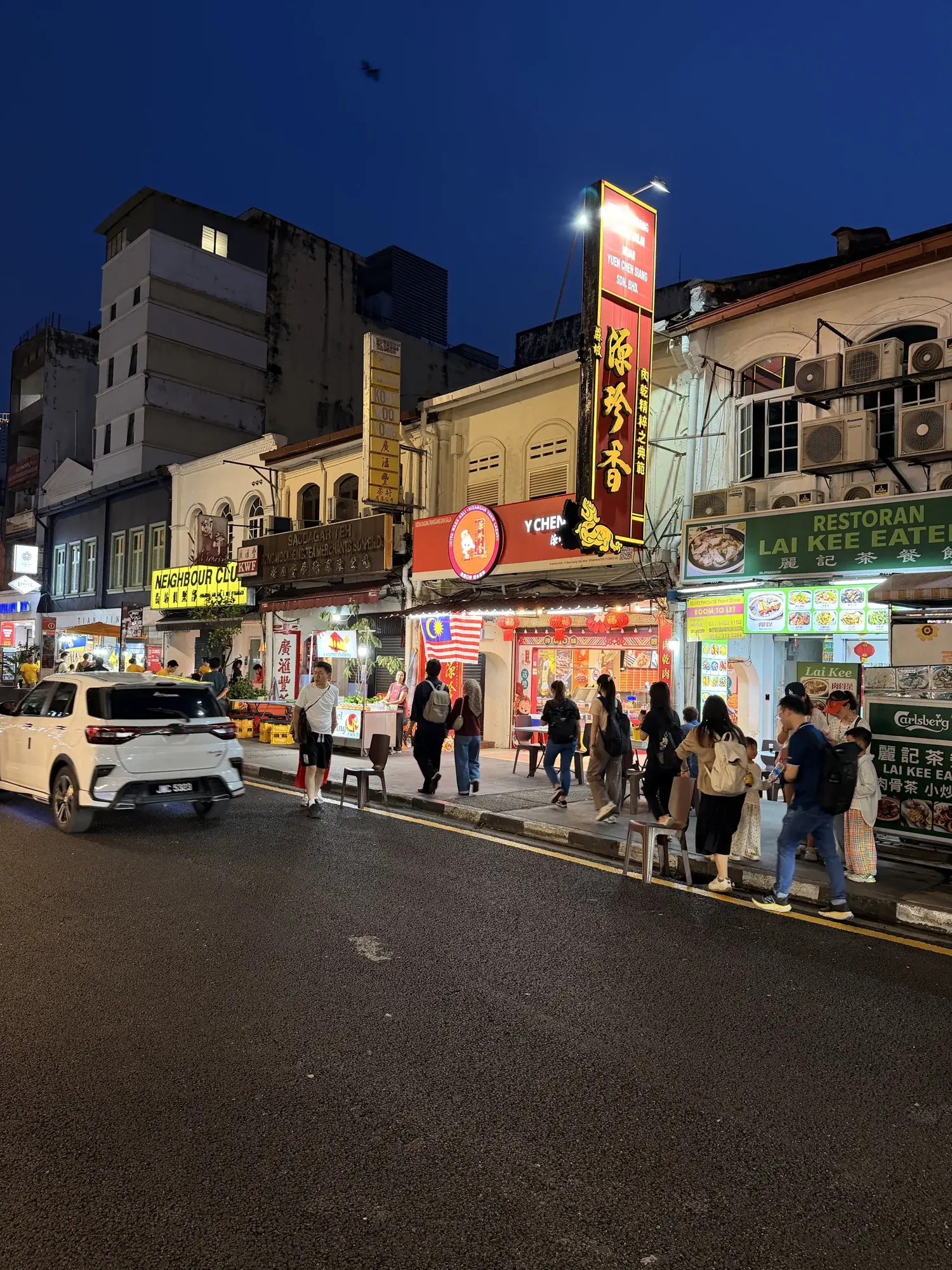 Abendliche Strasse mit Restaurants und Passanten in Kuala Lumpur