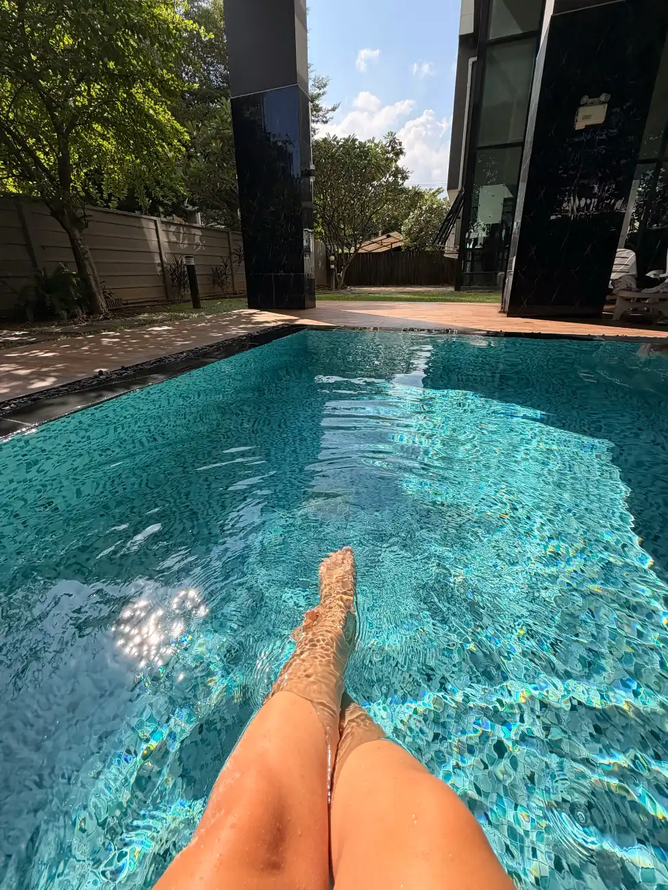 Beine im Pool einer Apartmentanlage in Chiang Mai